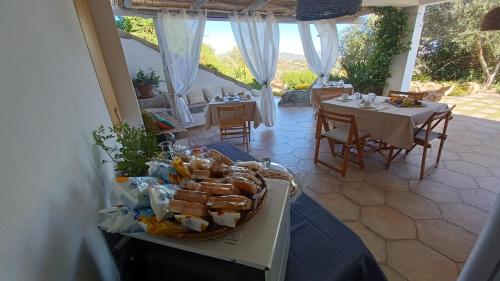 een tafel met een mand brood en tafels en stoelen bij Li Petri Manni in Olbia