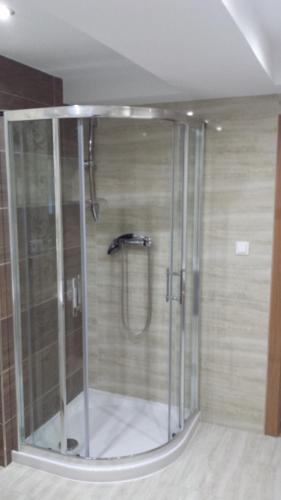 a shower with a glass door in a bathroom at Apartmány Korenko in Štrba