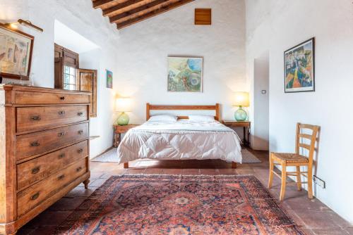 een slaapkamer met een bed, een dressoir en een stoel bij Finca Arroyo de las Adelfas in Málaga