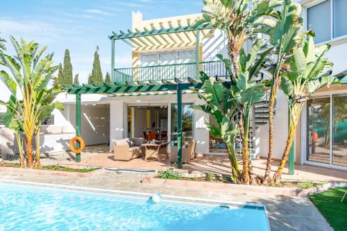 eine Villa mit Swimmingpool und ein Haus in der Unterkunft Villa Poseidon Gardens by Ezoria Villas in Larnaka