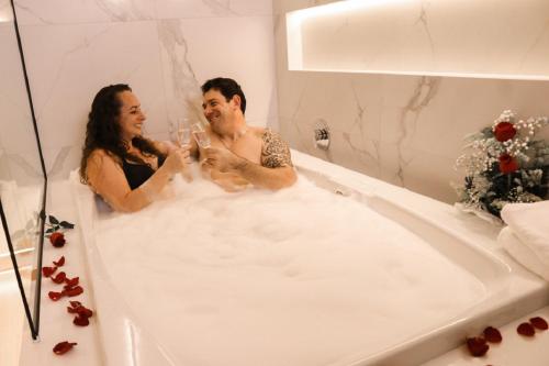 un hombre y una mujer sentados en una bañera en Estação Termas Hotel, en Piratuba