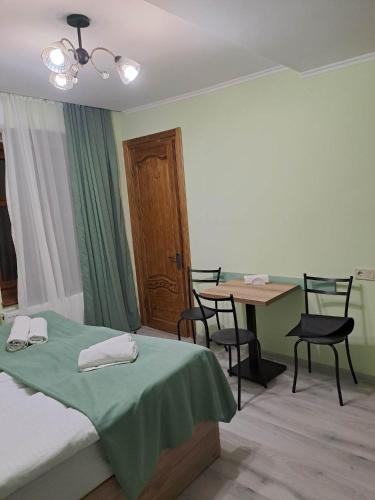 una habitación con una cama, una mesa y sillas en Apartment on Xancteli, en Tiflis