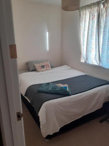 Dormitorio pequeño con cama y ventana en Carters Guesthouse, en Milton Keynes