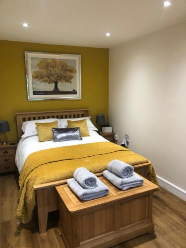 a bedroom with a bed with towels on a table at Littleton Farm Barns in Saham Toney