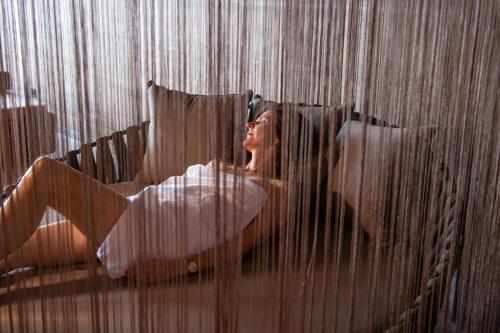 a woman laying in a bed with her head up at Hotel Walisgaden superior in Damuls