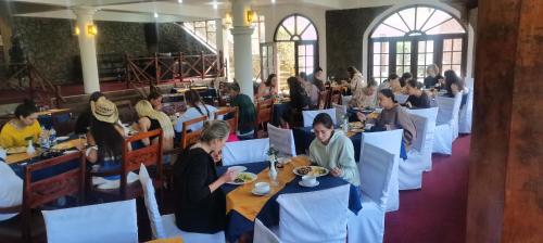 um grupo de pessoas sentadas em mesas em um restaurante em Hotel Silver Falls - Nuwara Eliya em Nuwara Eliya