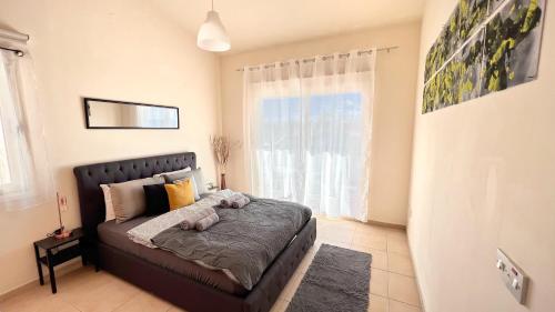 ein Schlafzimmer mit einem Bett und einem großen Fenster in der Unterkunft Melanos Sea View Apartment in Paphos City