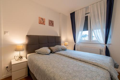 Un dormitorio con una cama grande y una ventana en Flexible SelfCheckIns 39 - Zagreb - Parking - New en Zagreb