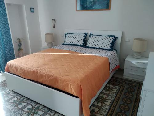 1 dormitorio con 1 cama con edredón de naranja en La casa di Trilly, en Mola di Bari