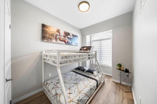 een slaapkamer met een stapelbed in een kamer bij Modern 4 Level home-Game room/Parking/Near Airport in Mississauga