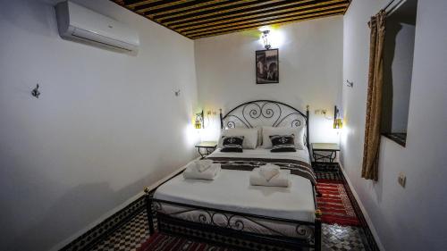 a bedroom with a bed with two pillows at Riad Green House in Fès