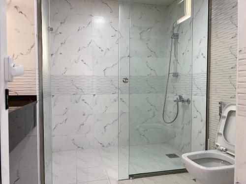 uma casa de banho com uma cabina de duche em vidro e um WC. em Turquoise Resorts em Ruwais