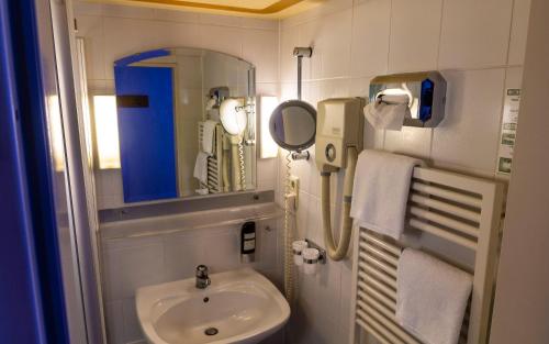 Trip Inn Aschaffenburger Hof في أشافنبورغ: حمام صغير مع حوض ومرآة