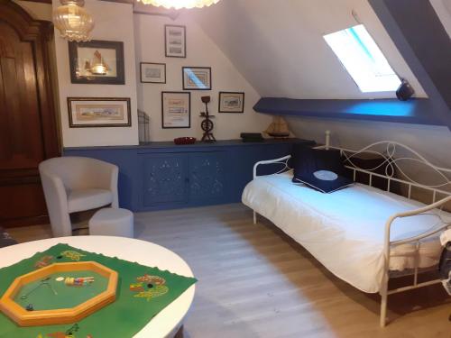 ein Schlafzimmer mit einem Bett und einem Tisch mit Agamuitous in der Unterkunft Chez Kat Location Ile de Groix in Groix