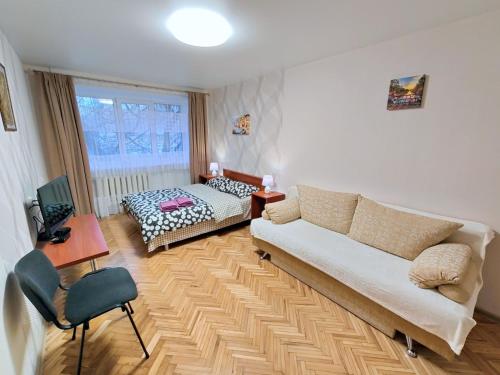 a living room with a couch and a bed at Bright and cozy apartments in the center in Vinnytsya