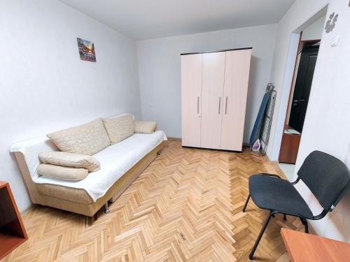 sala de estar con sofá y silla en Bright and cozy apartments in the center, en Vínnytsia