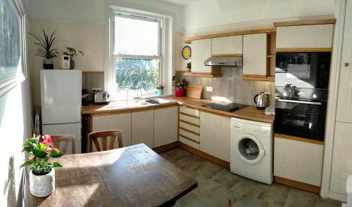 a kitchen with a table and a sink and a dishwasher at 1 Bed flat in East Dulwich in London