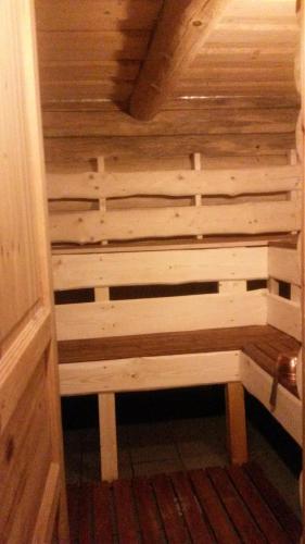 a wooden bench in a sauna in a room at Ezerkalni in Raiskums