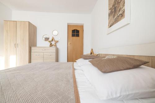 a bedroom with a white bed and a dresser at Willa Dunajec in Zakopane
