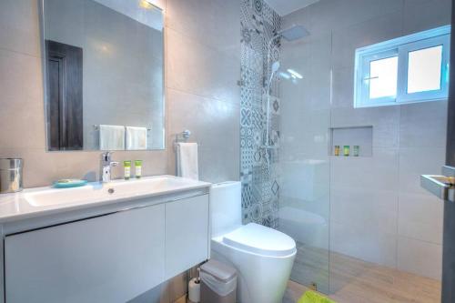 La salle de bains est pourvue de toilettes, d'un lavabo et d'une douche. dans l'établissement Ultra Cosy 2 Bedroom Beach Apartment - K-302, à Punta Cana