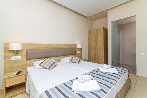 a hotel room with a bed with towels on it at Theo Star Beach Hotel in Malia