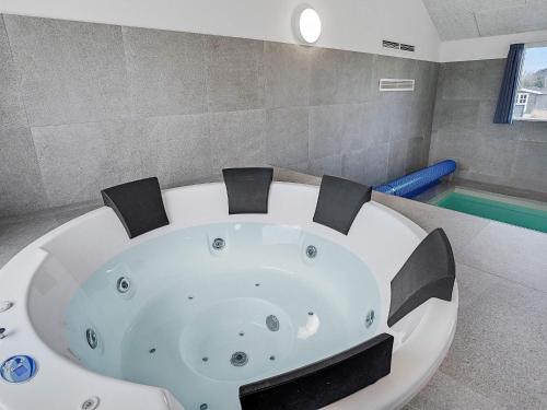 Seven-Bedroom Holiday home in Sydals في Høruphav: حوض استحمام أبيض في غرفة مع مسبح