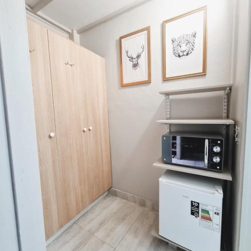 a small kitchen with a microwave and a refrigerator at Hostal Paso por La Serena in La Serena