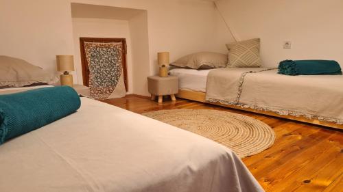 a bedroom with two beds and a wooden floor at Amorino Cres - Old Town House in Cres