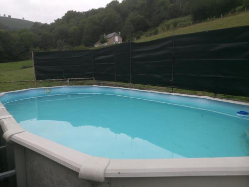 une grande piscine bleue avec une clôture dans l'établissement Maison individuelle au cœur de la Soule au pays basque, à Musculdy