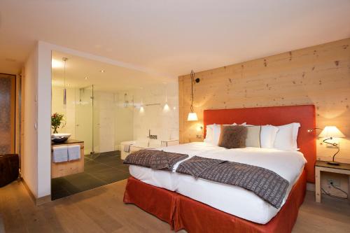 1 Schlafzimmer mit einem großen Bett und einem Badezimmer in der Unterkunft Matterhorn Lodge Boutique Hotel & Apartments in Zermatt