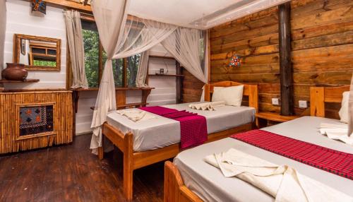 a bedroom with two beds and a fireplace at Miseni Retreat in Saadani