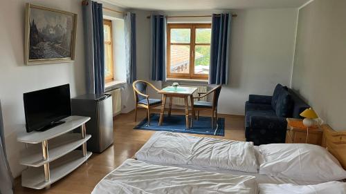 ein Wohnzimmer mit einem Bett und einem Tisch mit Stühlen in der Unterkunft Landgasthof Jägerhaus in Immenstadt im Allgäu