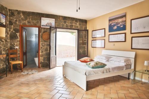 a bedroom with a bed and a stone wall at Villa La Caletta in Carloforte