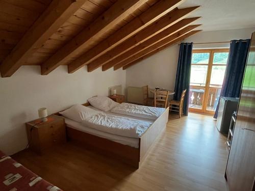 ein Schlafzimmer mit einem Bett in einem Zimmer mit Holzböden in der Unterkunft Landgasthof Jägerhaus in Immenstadt im Allgäu