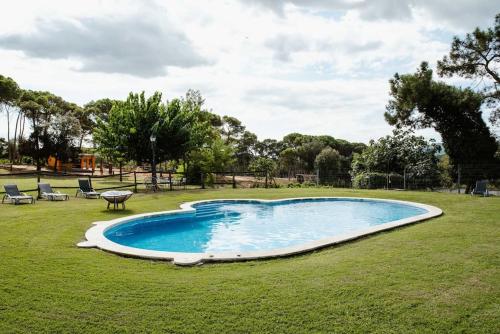 einen Pool im Garten mit Stühlen und einem Tisch in der Unterkunft LOS TILOS Casa rural en el campo. in Tordera