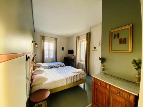 a bedroom with two beds in a room with green walls at Hotel Le Midi Clermont-Cournon in Cournon-dʼAuvergne