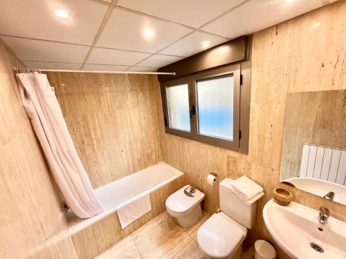La salle de bains est pourvue de toilettes, d'un lavabo et d'une baignoire. dans l'établissement Apartamento Vive Zaragoza IV, à Saragosse