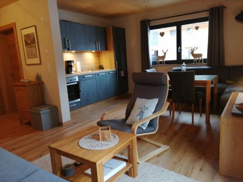 a living room and kitchen with a table and a chair at Hoamatgfühl in Vorderhornbach