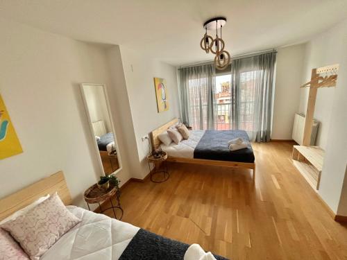 1 dormitorio con 2 camas y ventana grande en Apartamento Vive Zaragoza IV, en Zaragoza