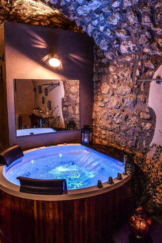 a large tub in a room with a stone wall at Vicolo72 in Calitri