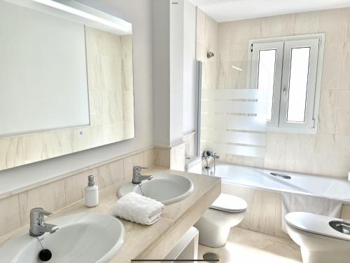 MI CAPRICHO 172 Beachfront Apartment في Sitio de Calahonda: حمام مغسلتين ومرحاض ومرآة
