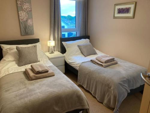 sypialnia z 2 łóżkami i ręcznikami w obiekcie Beautiful 2 bedroom flat overlooking golf course w mieście Carnoustie