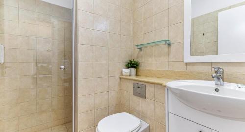 Un baño con inodoro, lavabo y espejo. en Modern Apartment U2 - Zias with lovely views in heart of Aphrodite Hills, en Kouklia