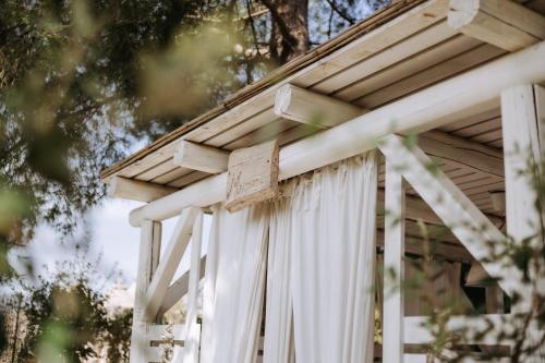 a white pergola with white curtains on it at Tenuta del Lauro in Locorotondo