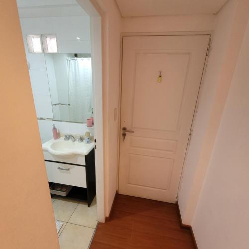 ein Badezimmer mit einer weißen Tür und einem Waschbecken in der Unterkunft Salta Hills in Salta