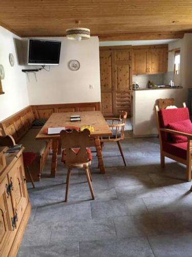 een keuken met een tafel en stoelen en een koelkast bij Scuol in schönem Engadinerhaus in Scuol