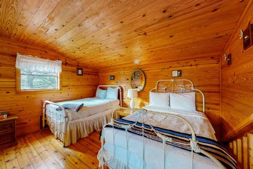 a bedroom with two beds in a log cabin at Charlie's Ol' Fishing Cabin in Eureka Springs