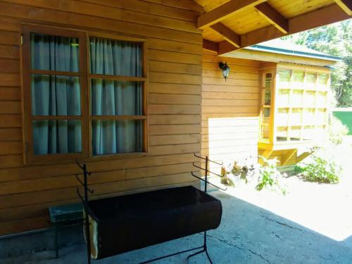 Cabaña céntrica Pucón في بوكون: مقعد على الجانب الخارجي من المنزل
