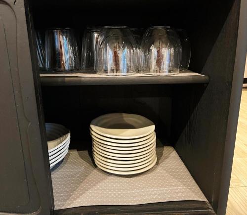 a cabinet filled with plates and bowls on shelves at ENSO Residence 古民家一棟貸切宿 東近江市五個荘 ペット可 定員6名 in Higashiomi