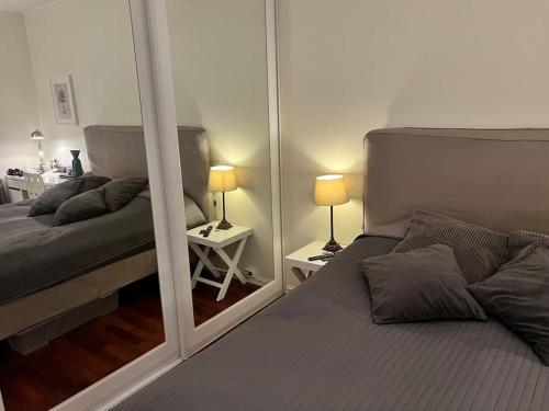 オスロにあるOslo City Apartmentのベッドルーム1室(ベッド2台、大きな鏡付)